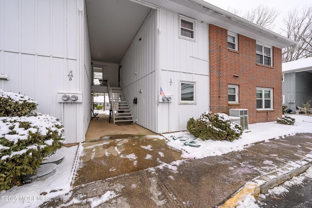 snow covered property featuring central AC