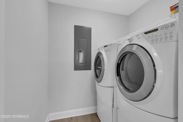 laundry area with hardwood / wood-style flooring, electric panel, and washer and clothes dryer