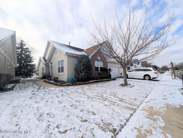 snow covered property with a garage