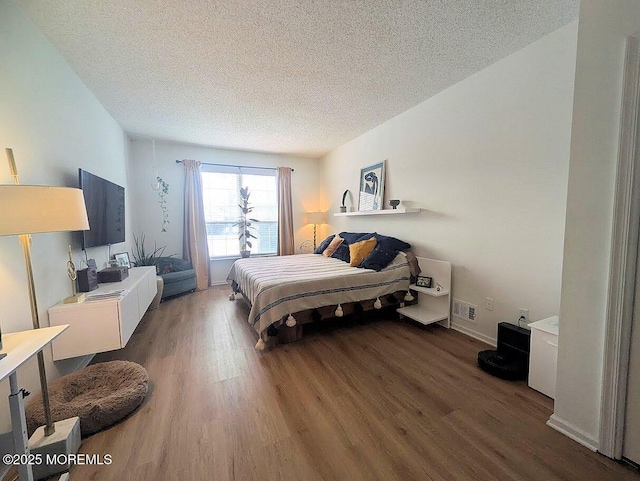 bedroom with hardwood / wood-style floors and a textured ceiling