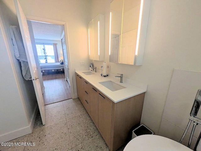 bathroom featuring a textured ceiling, toilet, and vanity