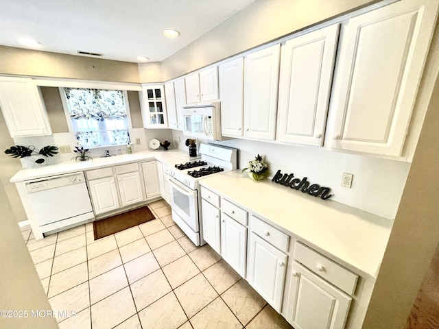 kitchen featuring white cabinetry, light tile patterned floors, and white appliances