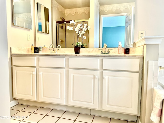 bathroom with tile patterned floors, vanity, and a shower with door