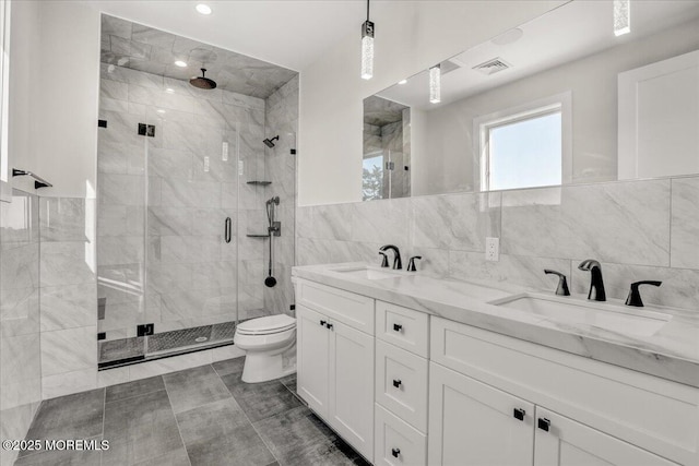 bathroom with tile walls, backsplash, vanity, walk in shower, and toilet