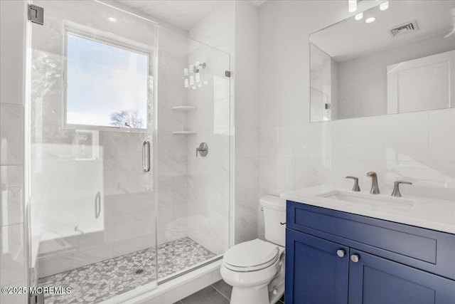 bathroom featuring toilet, an enclosed shower, tile walls, vanity, and backsplash