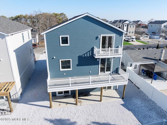 rear view of property featuring a patio area and a balcony