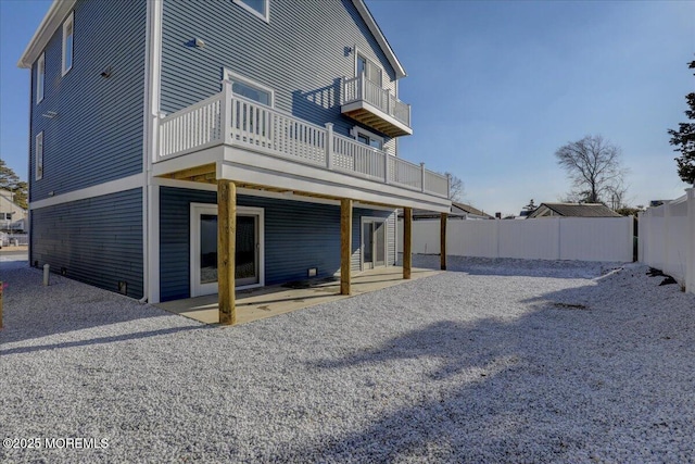 back of property featuring a balcony and a patio area