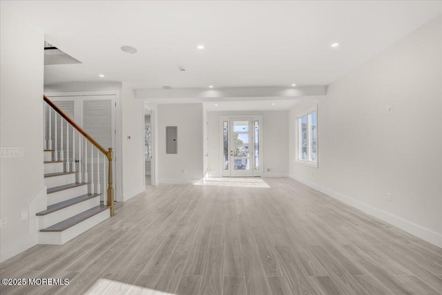 unfurnished living room with electric panel and light wood-type flooring