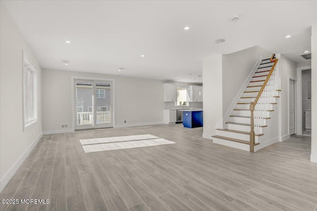 unfurnished living room with a wealth of natural light and light wood-type flooring