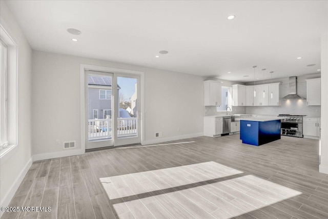 unfurnished living room with sink and light wood-type flooring