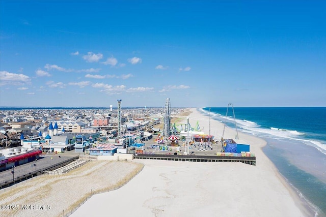 drone / aerial view featuring a water view and a view of the beach