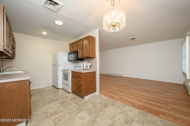 kitchen with sink, white appliances, a baseboard heating unit, decorative light fixtures, and a chandelier