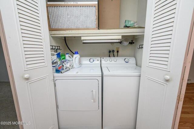 clothes washing area with wood-type flooring and independent washer and dryer