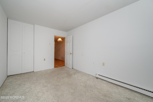 unfurnished bedroom featuring a baseboard radiator, a closet, and light carpet