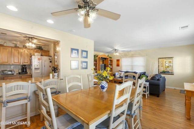 dining area with ceiling fan and light hardwood / wood-style floors