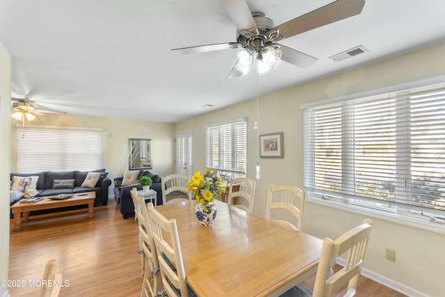 dining area with ceiling fan and light hardwood / wood-style floors