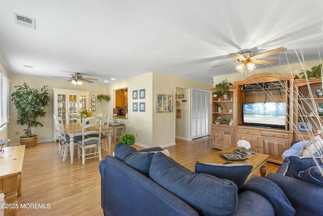 living room with ceiling fan and light wood-type flooring