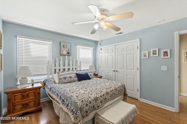 bedroom with ceiling fan, wood-type flooring, and a closet