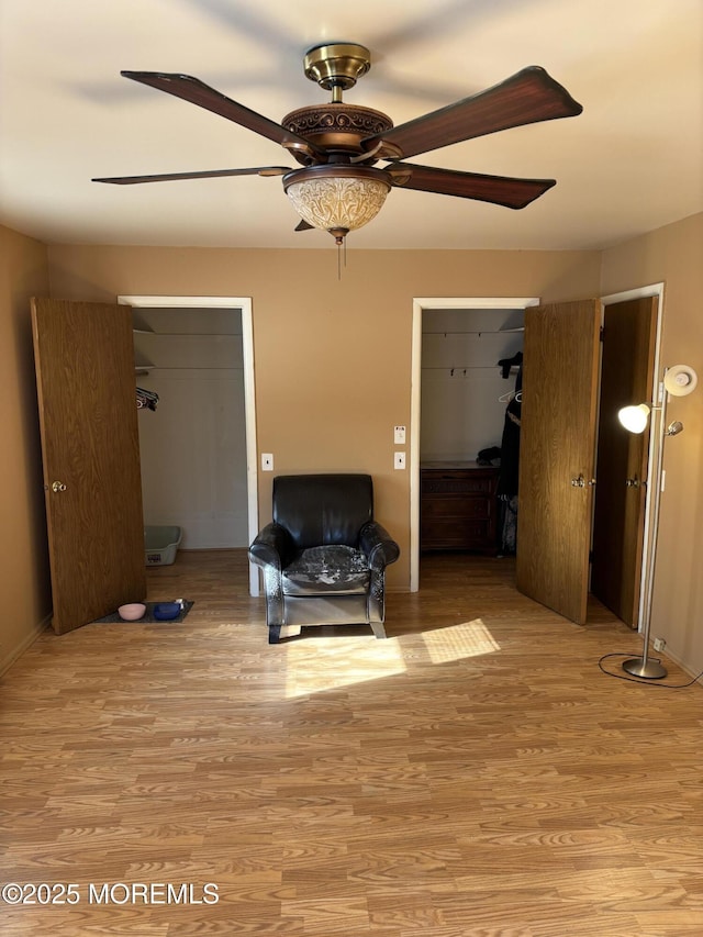 living area with ceiling fan and light hardwood / wood-style flooring