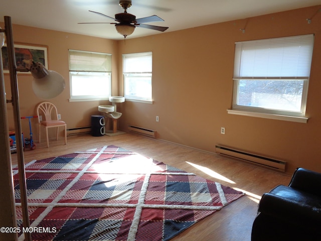 unfurnished bedroom featuring baseboard heating, ceiling fan, and wood-type flooring