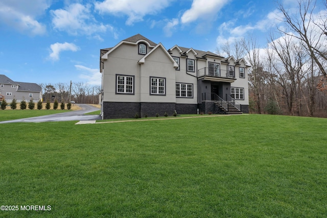 view of front facade featuring a front lawn and a balcony