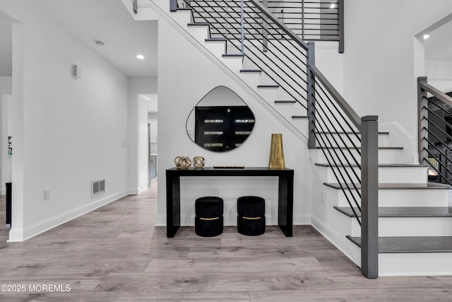 staircase featuring hardwood / wood-style flooring and a high ceiling