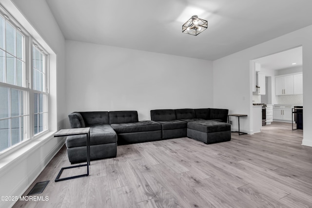 living room with plenty of natural light and light hardwood / wood-style flooring