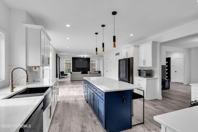 kitchen featuring blue cabinets, white cabinetry, sink, hanging light fixtures, and black appliances