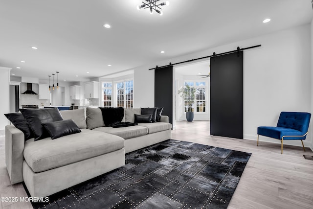 living room with a barn door and hardwood / wood-style floors