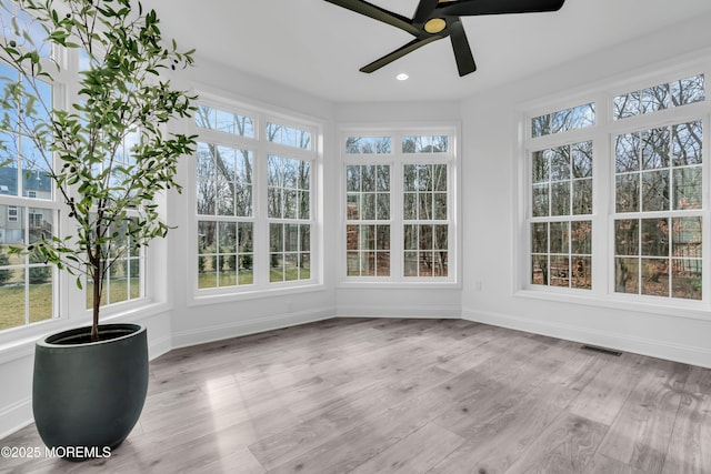 unfurnished sunroom featuring ceiling fan