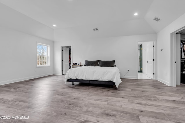 bedroom featuring lofted ceiling and light hardwood / wood-style floors