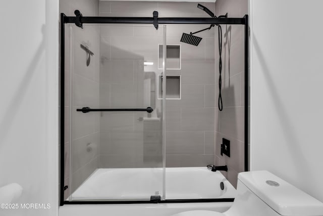 bathroom featuring shower / bath combination with glass door and toilet