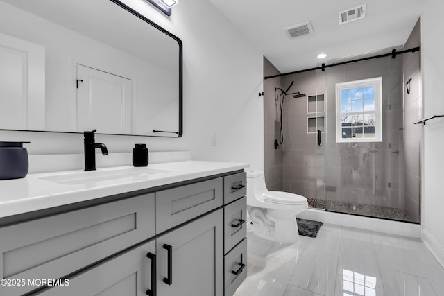 bathroom featuring vanity, toilet, and a shower with door