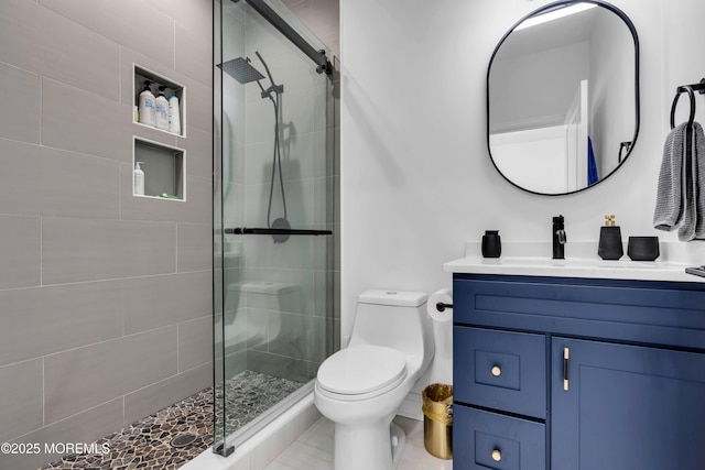 bathroom with vanity, a shower with shower door, and toilet