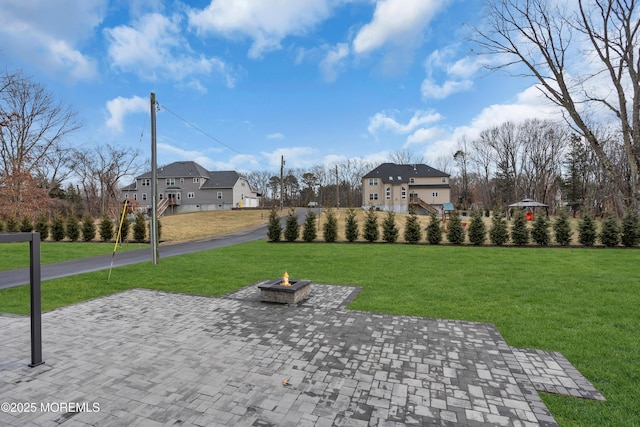 view of property's community featuring a yard and a fire pit