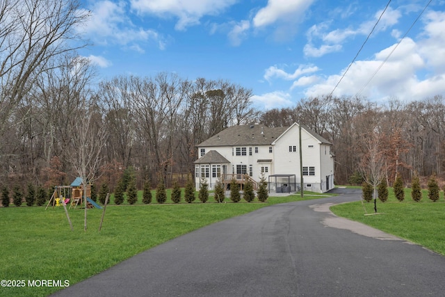 view of front of house with a playground and a front yard