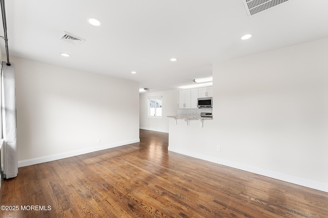 unfurnished living room featuring dark wood-type flooring