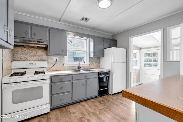 kitchen with gray cabinetry, sink, white appliances, and plenty of natural light