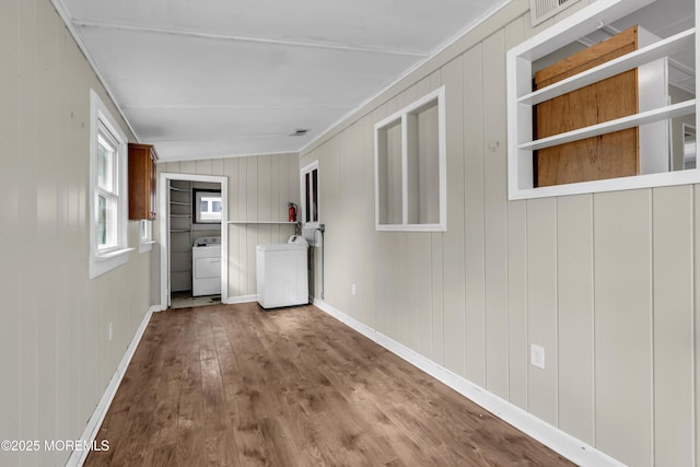 interior space featuring washer / clothes dryer, wood-type flooring, and ornamental molding