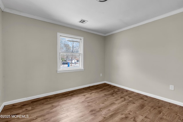 empty room featuring wood-type flooring and crown molding