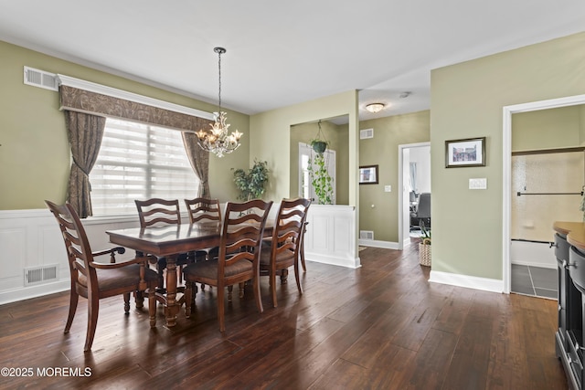 dining space with dark wood-type flooring, a wealth of natural light, and a notable chandelier