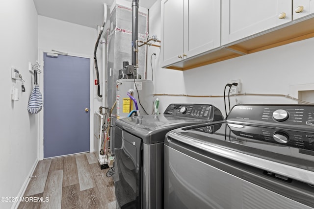 laundry area with separate washer and dryer, hardwood / wood-style floors, gas water heater, and cabinets