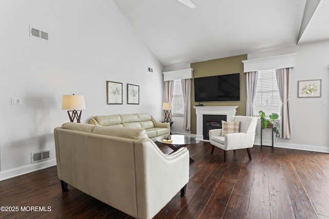 living room with dark hardwood / wood-style flooring and high vaulted ceiling