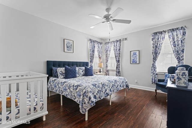 bedroom featuring hardwood / wood-style flooring, ceiling fan, and multiple windows