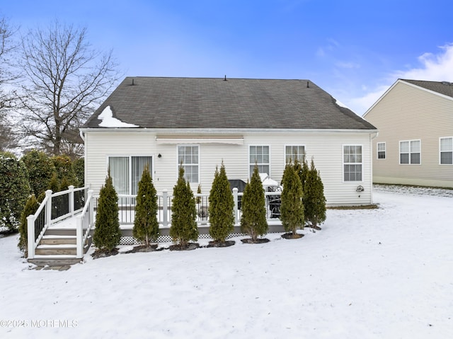 snow covered house featuring a deck