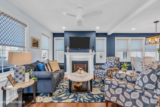 living room featuring beam ceiling, hardwood / wood-style flooring, and ceiling fan