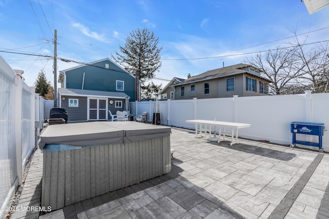 view of patio featuring a hot tub and an outdoor structure