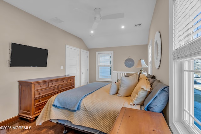 bedroom featuring ceiling fan, wood-type flooring, vaulted ceiling, and multiple windows