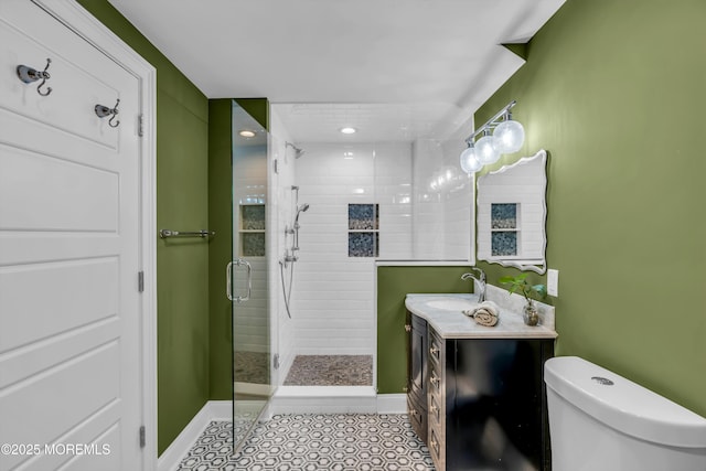 bathroom with vanity, tile patterned floors, toilet, and walk in shower