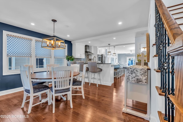 dining room featuring ceiling fan with notable chandelier, dark wood-type flooring, and sink